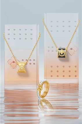 水面与半透明几何展板之间的金色项链与戒指