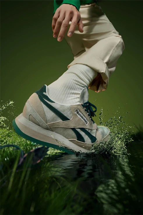 Reebok 运动鞋上脚特写，绿色水景衬托米白色与深绿鞋身