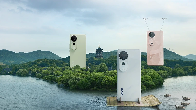 不同配色的 vivo S19 机身出现在湖岸林木上方